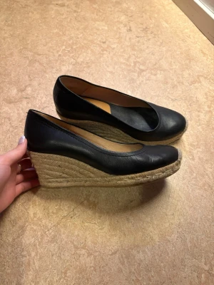 Svarta wedgespumps med flätad kilklack - Snygga svarta pumps med rund tå och kilklack i flätad jute. Ovandelen är i svart läderimitation och klacken ger extra höjd utan att tumma på komforten. Perfekta för dig som vill ha en stilren sko med lite boho-vibe.  Mycket fina inför sommaren och mycket annat. Hör av dig vid intresse⭐️