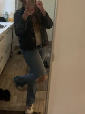 Blå jeans - Säljer ett par blå raka jeans med slitningar vid knäet. Jeansen har en klassisk femficksmodell och normal midja. Perfekta för en avslappnad och trendig stil 