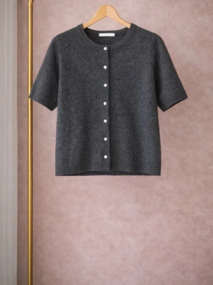 Mörkgrå kortärmad kofta - Kortärmad kofta i mjuk mörkgrå ullmix med rund halsringning och vita knappar framtill. Enkel och stilren design som passar perfekt till lager på lager. Rak passform och ribbade kanter för en clean look.