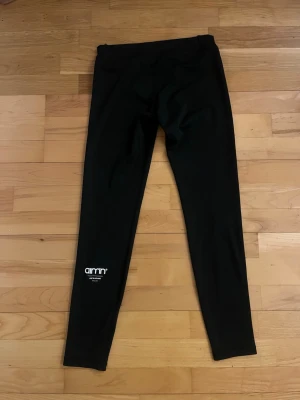 Svarta leggings från Aim'n - Säljer ett par svarta leggings från Aim'n med logga tryckt vid benet (baksidan). Nypris 699kr 