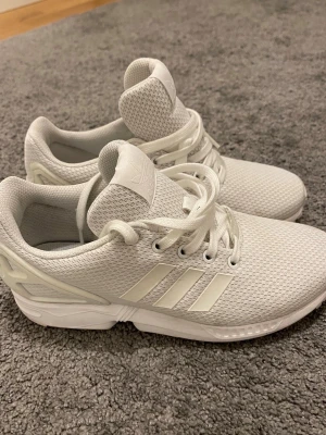 Vita Adidas ZX Flux sneakers - ✨Säljer ett par helvita Adidas ZX Flux sneakers med klassiska tre ränder på sidan. Strl 37 1/3✨