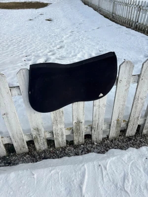 Svart sadelpad från Acavallo - Säljer en svart sadelpad från Acavallo med mjukt material och ergonomisk form. Perfekt för att ge extra komfort och stöd under ridning. Diskret Acavallo-logga i hörnet och stilren design som passar de flesta sadlar.