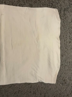 Vit bandeau tubtopp från Gina Tricot - Säljer en enkel och stilren vit bandeau tubtopp från Gina Tricot. Toppen är axelbandslös och har en rak passform💞