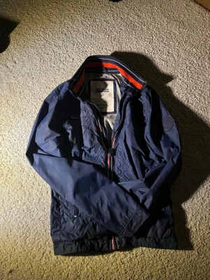 Hilfiger Denim Jacka - Säljer denna perfekta jacka nu när våren är på ingång. Den har vissa tecken på användning men som påverkar användningen av jackan. Perfekt att ha över en långarmad tröja, och på varmare vårdagar så kan du till och med slippa ha en långarmad under, och endast köra på T-shirt ;) Strl: S