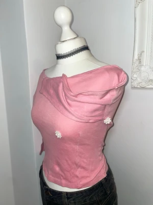 Vintage 50-tal Rosa offshoulder topp med blommor - Äkta retro 1950-tal rosa offshoulder topp med små vita blommor som detaljer. Superfin och skräddad för smal midja. Mjuk bomull.