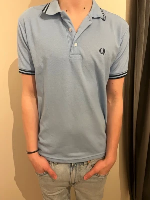 Ljusblå piké från Fred Perry   - Säljer en ljusblå piké från Fred Perry I storlek M.  Nypris 1095kr (Priset kan diskuteras)