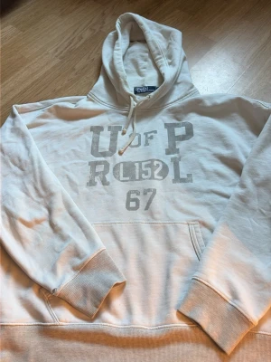 Vit hoodie från Polo Ralph Lauren - Säljer denna sjukt eftertraktade och unika hoodie från Ralph Lauren! Hoodien har använts en del vilket har resulterat i två defekter (se bilder). Storlek M. Hoodien kan bara hittas begagnat och är svår att hitta men pågrund av defekterna säljs denna billigare. Hör av er vid frågor och funderingar!🤝