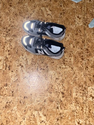 Svarta och grå VENOM sneakers - Snygga sneakers från VENOM i svart och grått med vita detaljer. Skorna har en chunky sula och reflekterande partier framtill. Ovandelen är i mesh och syntetmaterial, med snörning och tydlig logga på sidan. Perfekta för en streetwear-look.