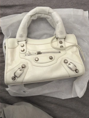 Vit handväska med silverdetaljer - Vit handväska. Helt oanvänd 