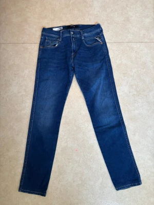 Mörkblå raka jeans från Reaplay  - Snygga mörkblå jeans från Reaplay med raka ben och klassisk femficksdesign. Jeansen har silverfärgade knappar och dragkedja, samt dekorativa sömmar på bakfickorna. Tillverkade i ett mjukt denimtyg som sitter skönt hela dagen.
