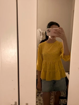 Gul blommig volangblus - Söt gul blus med små blommor och volanger. Blusen har rund halsringning och trekvartsärm med lätt puff. Perfekt för dig som vill ha en färgglad och trendig look. Materialet känns lätt och luftigt.skit snygg me shorts eller kjol som jag har 