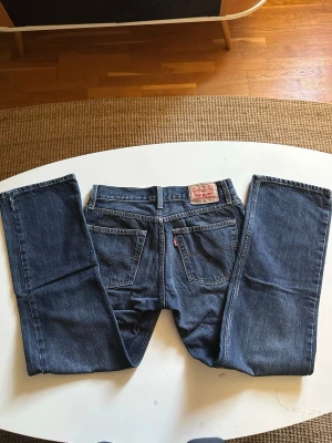 Levi's blåa bootcut jeans - Säljer ett par klassiska blåa bootcut jeans från Levi's. Jeansen har en bredare passform nertill och är gjorda i slitstark denim. Perfekt för dig som gillar en avslappnad och cool stil.