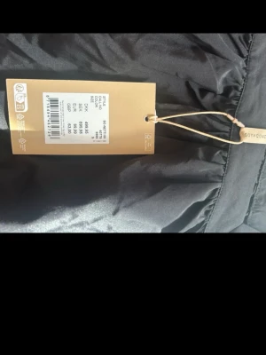 Svart blus med spets från Soyaconcept - Trendig svart blus från Soyaconcept med långa ärmar och snygga spetsdetaljer vid halsringning och ärmslut. Blusen har en rak passform och är tillverkad i ett lätt material som ger en elegant look.