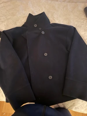 Marinblå vårjacka  - Stilren marinblå skepparkavaj med dubbelknäppning och bred krage. Från Ginatricot i strlk M, säljer pga den inte kommer till användning. Man kan bära den på olika sätt som jag visar i bilderna. Jätte skön till våren. 😊