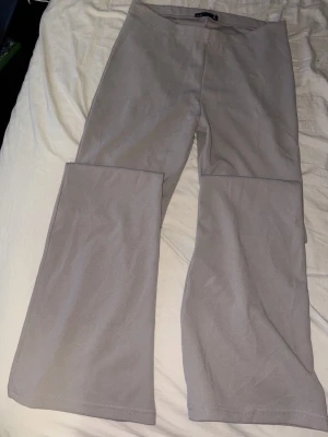 Beige utsvängda leggings M - Säljer ett par beige leggings från Lager 157 med utsvängda ben. De har en mjuk och stretchig känsla, perfekta för en avslappnad och trendig look. Midjan är normalhög och materialet känns lent mot huden. Storlek M