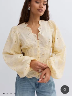 Gul broderad blus  - Söt gul blus med broderade detaljer och genombrutna mönster. 