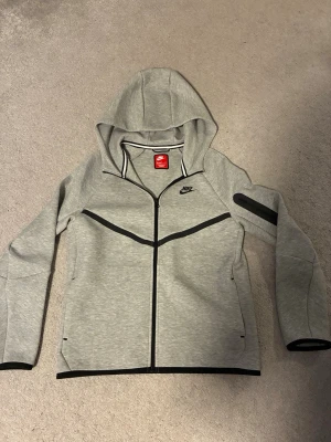 Grå Nike hoodie med dragkedja XL - Säljer nu min niketech siphoodie den är aldrig använd skriv om ni undrar något och priset kan diskuteras 