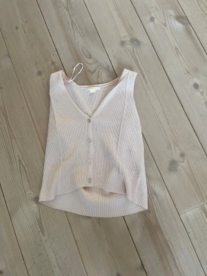 Ljusbeige ribbad linnetopp Gina Tricot - Säljer en ljusbeige ribbad linnetopp från Gina Tricot. Toppen har v-ringning, knappar framtill och är ärmlös. Perfekt till sommaren och enkel att matcha med olika stilar.