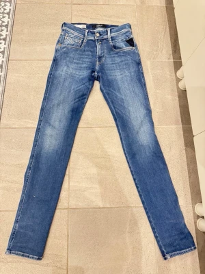Replay Anbass Jeans – W27/L32 - Replay Anbass Jeans – W27/L32  Säljer ett par stilrena Replay Anbass-jeans i storlek W27/L32. Jeansen är i mycket fint skick och har endast använts ett fåtal gånger eftersom de tyvärr var något för små.  ✔ Original Replay Anbass-modell ✔ Mycket gott skick ✔ Använda få gånger  Hör gärna av dig vid frågor eller intresse.