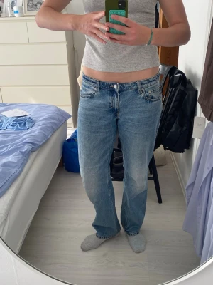 Blå lågmidjade jeans från Weekday - Blå lågmidjade jeans från Weekday med rak passform. Jeansen är i jättebra skick och är i storleken W32L34 så är längre i benen.
