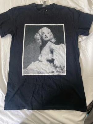 Svart t-shirt med konstmotiv L'ARTE - Fin svart tröja med Marilyn Moroe på framsida i svart och vitt. 