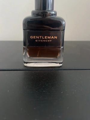 Givenchy Gentleman Reservée Privée parfym - Givenchy Gentleman parfym i en elegant, mörk glasflaska med stilren design.. Doften är maskulin och exklusiv, perfekt för dig som vill sticka ut med en lyxig signaturdoft. Det är ungefär 30 ml i flaskan, den är alltså halvfull (60ml från början).