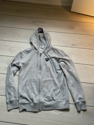 Grå hoodie Comme des Garçons Play - Säljer en riktigt fet CDG zip i mycket bra skick. Killen på bilden är 173. Skriv vid frågor