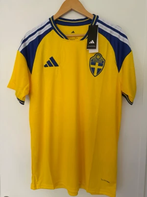 Sverige 299kr VM storlek XL Ny med tags - 🇸🇪 Sverige VM Hemmatröja – Strl XL 🇸🇪  Snygg Sverige VM hemmatröja i klassisk gul design med blå detaljer. En stilren och tidlös landslagströja som passar perfekt för både fotbollsfans och samlare.  ✨ Helt ny med tags kvar 📏 Storlek XL ⚽ Hög kvalitet och bekväm passform 🔥 Perfekt till matchdagar, träning eller vardagsbruk 🇸🇪 Klassisk hemmadesign med fina detaljer  Skick: Oanvänd  💰 Pris: 299 kr  📦 Kan skickas eller hämtas enligt överenskommelse.  En riktigt snygg Sverige-tröja för dig som vill visa
