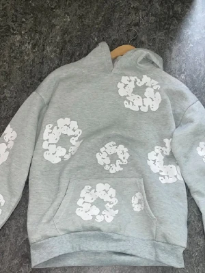 Grå hoodie med vita tryck - Denim Tears hoodie i mycket fint skick. Grå färg med vita Cotton Wreath-detaljer.
