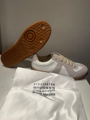  vit/beige Maison Margielas gats - Maison Margiela gats i vitt och beiget med klassisk gummisula. Skorna är helt nya med storlek 44 men passar även 43. Perfekta för dig som gillar minimalistisk och stilren design. 