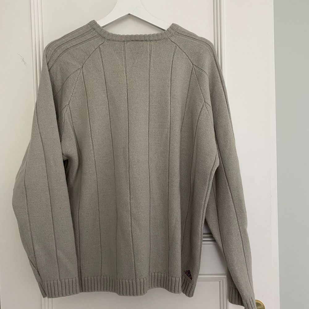 En grå stickad adidas tröja som är köpt secondhand  i Köpenhamn. Den är till viss del lite stickig men funkar jättebra om man har ett linne under eller liknande. Är i storlek L men blir inte jätte oversized på mig som är M/L. Stickat.