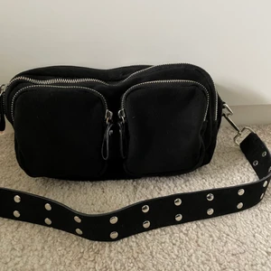 Svart väska - Säljer min svarta väska från Gina tricot med fyra fack och ett fint band med nitar.