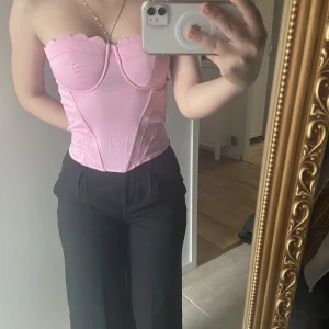 rosa korsett - En rosa korsett köpt från secondhand. Storlek XS/S. Säljer pga inte passar mig i bysten. Skriv för fler frågor/bilder. Silkematerial.