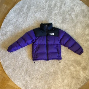 Lila The North Face Jacka - Lila TNF Jacka i storlek i fint skick dock lagad med laglapp på baksidan, anledning till priset men märks knappt. Finns att hämta i Uppsala men kan också skicka