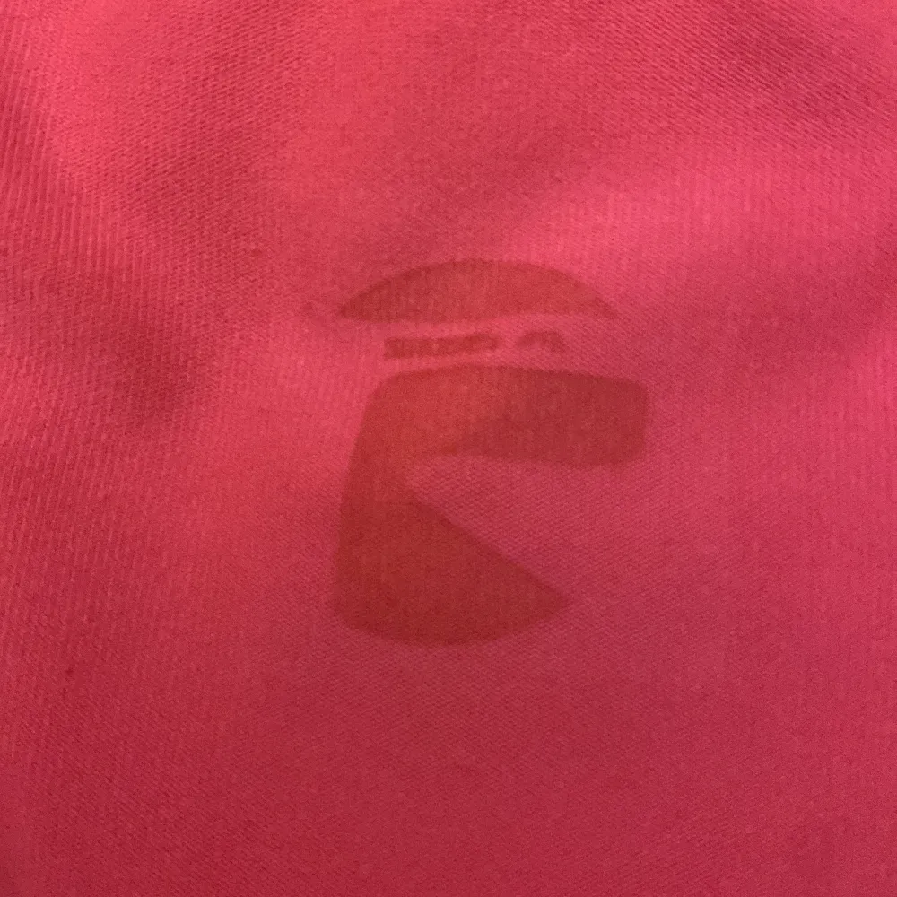 Det är ett rosa tränings linne med svarta dittaljer. Toppar.