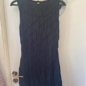 Festklänning  - Fransig kort klänning från märket Amisu. Öppen i ryggen och tightpassform. Väldigt cool att ha på stan för att fransarna rör sig med kroppen. 