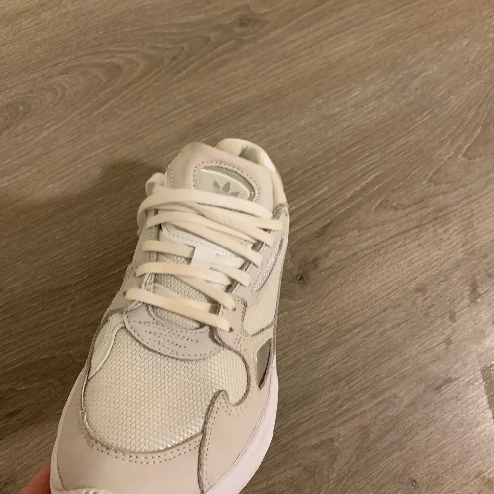 Falcon Sneakers från Adidas  Färg: beige/vita   Storlek: 38 alt. se bild Skick: använda ett fåtal ggr, finns inget att anmärka på  . Skor.