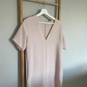 En smuts rosa klänning i ett tunt material med fickor. Perfekt för sig själv eller med ett par tights under. Använd fåtal gånger🥰