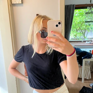 T-shirt - Svart, lite kortare över magen med söm som viks in ifrån weekday. 