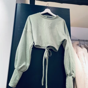 Top strl. 42 (liten) - Salviagrön top med fin öppen rygg och knyt i sweatshirt material.