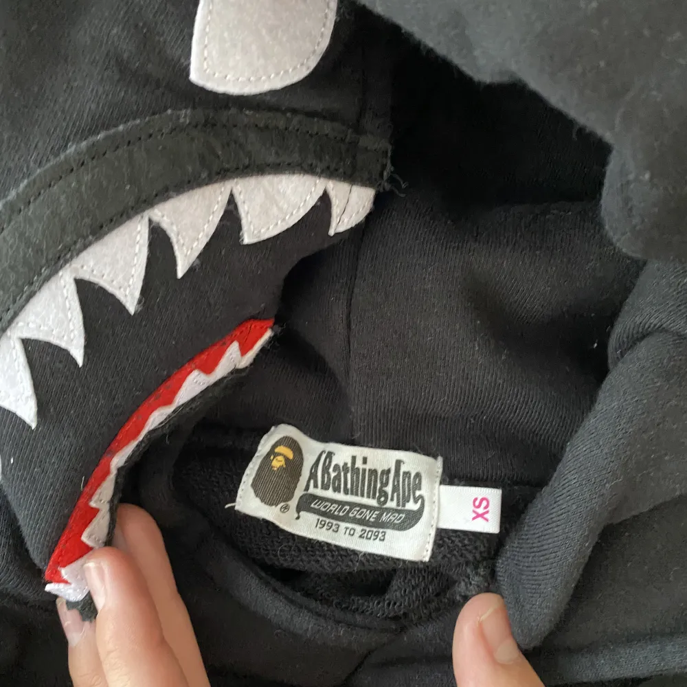 Bape shark hoodie, köpt på bape butik i Tokyo, Japan och därav 100 % äkta. Den är knappt använd och endast tvättad 1 gång, därav helt nyskick. Påsen på bilden är det enda OG jag har kvar. Den är i storlek XS, i japanese sizing. . Hoodies.