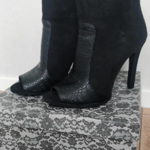 Högklackar - Högklackar från Nelly, oanvända strl 38, svarta med fake mocka och skinn detaljer.