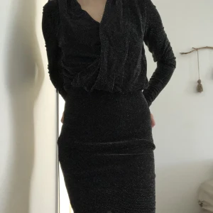Svart klänning - Svart glittrig klänning med pösig överdel