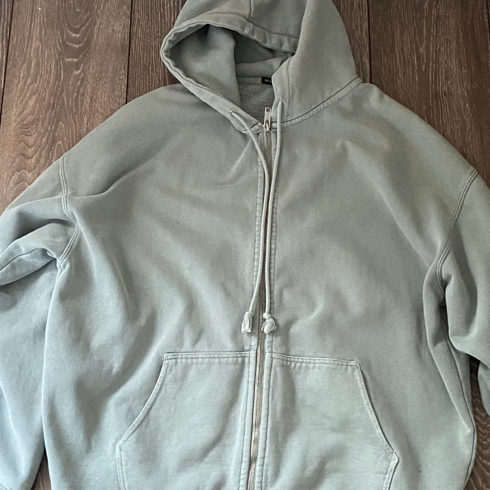 En grå/grön hoodie från Brandy Melville. Den är i bra skick. Orginal priset är ungefär 400kr. Köparen står för frakten!. Hoodies.