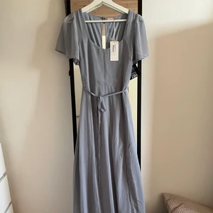 Helt ny balklänning, babyblå strl 36 - Helt ny babyblå balklänning / långklänning från Nelly i storlek S/36. Aldrig använd! Slits vid slutet, knyt i midjan, finns dragkedja. Finns ej kvar i sortimentet! Frakt tillkommer💕 nypris ca 799kr