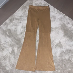 Beige/bruna mocka byxor  - Säljer dessa coola mockabyxor som sitter som ett par kostym, dom har sömmar vid knäna och en dragkedja på vänster sida av höften. Dessa är köpa på nätet från Boozt, dom har använda ett fåtal gånger. Bara att skriva för fler bilder och info!❤️‍🔥