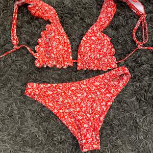 Blommig röd bikini som aldirg är andvänd, storlek s i båda delarna.