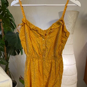 Playsuit - Kort playsuit med gulliga prickar. Väldigt söt på och bra passform. Har justerbara band. Är lite skrynklig på bilderna. 
