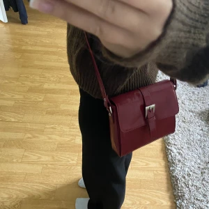 Vinröd axelremsväska  - Säljer min mammas gammla väska! Den är i mycket bra skick och har inga defekter. 