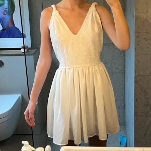 Klänning - Superfin vit kort klänning. Öppen rygg som ni ser på bild 3 och många fina detaljer. Står tyvärr inte storlek, men jag brukar ha XS/S och på mig passar den jättebra. Passa på redan nu och köp en perfekt studentklänning ❤️